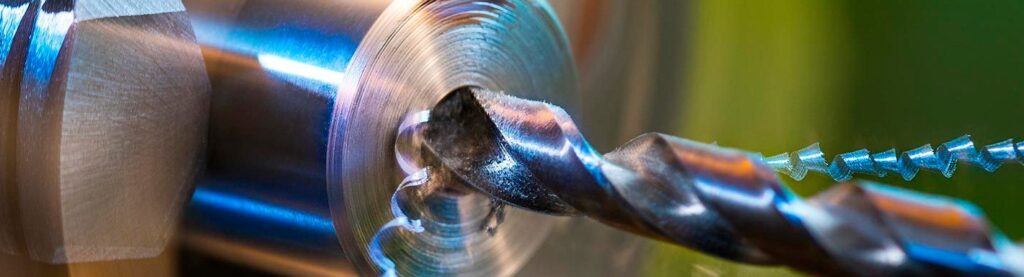 Precision drilling of thick metals using a tapper shank drill
